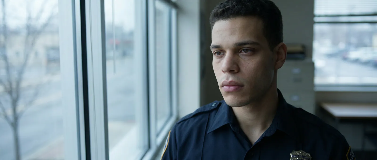 Close portrait of the police officer beside a window