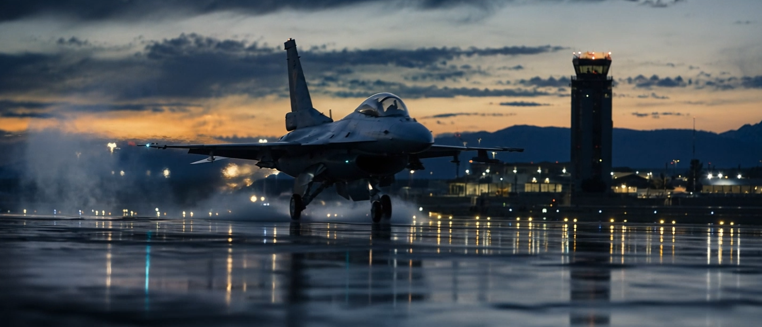 Fighter jet taxiing on a wet runway at dusk